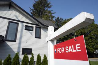 Picture of a home with a for sale sign (Taehoon Kim/Bloomberg via Getty Images)