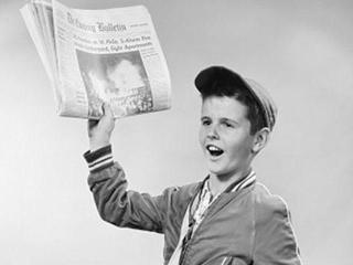 boy holding a newspaper